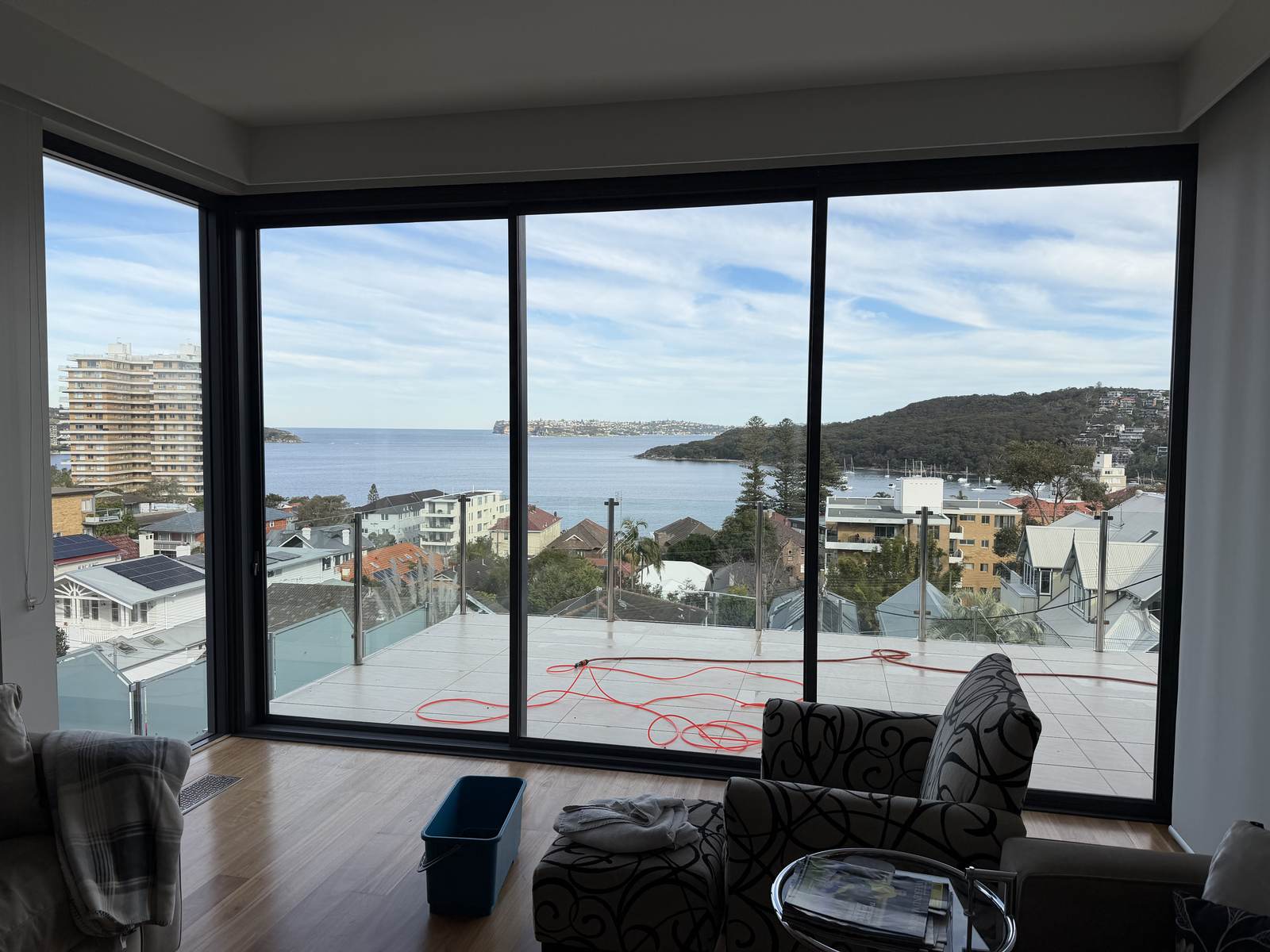 Lounge with sliding glass doors opening to a balcony and water views, cleaned by Coastal Clear Windows