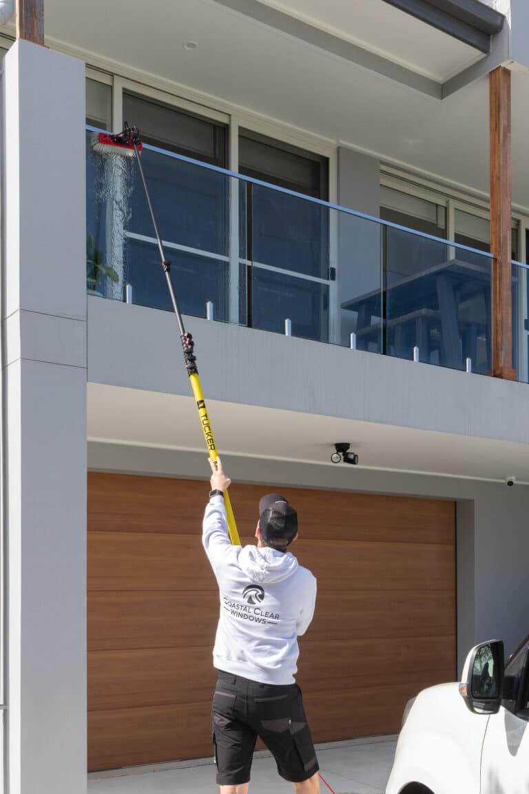Coastal Clear Windows cleaner working on exterior windows